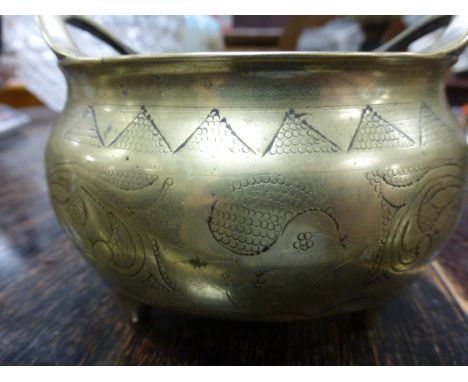 A Chinese twin handled brass censor; with scroll decoration; raised on three feet; bearing six character seal mark to base