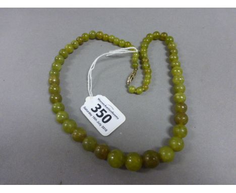 A Chinese jade necklace; the beads of graduating spherical form, with sterling silver clasp