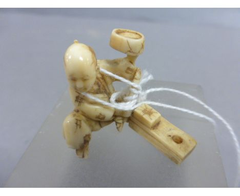 A small Chinese ivory netsuke in the form of a male carpenter; with detailed decoration