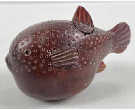 A small Japanese carved fruitwood snuff pot in the form of a pufferfish. Set with small mother of pearl disc insert to base w