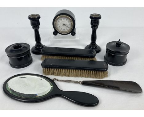 A vintage 9 piece ebony dressing table set. Comprising: a pair of candlesticks, clock, 2 x clothes brushes, hand mirror, butt