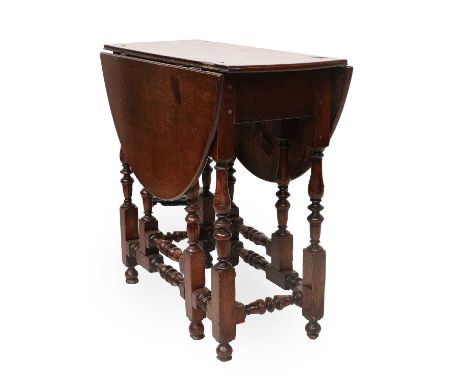 An Early 18th Century Jointed Oak Gateleg Table, with two moulded dropleaves to form an oval, on baluster-turned block suppor