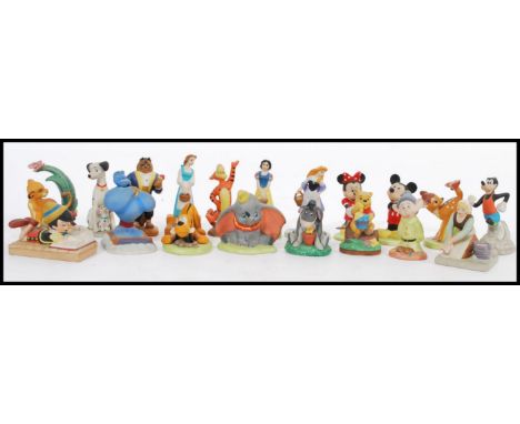 A selection of ceramic Disney character figurines to include Cinderella, Belle, Eyore, Simba, Dumbo, Bambi, Genie, Mickey Mou