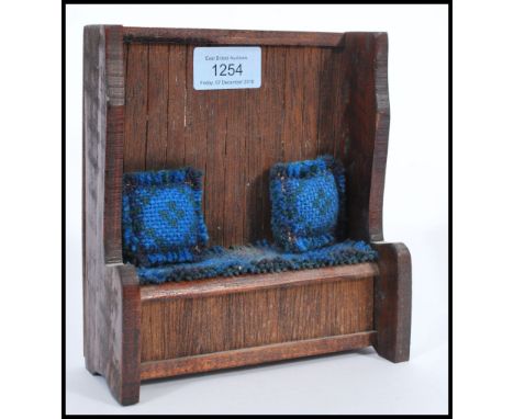 A 20th century apprentice piece hall settle bench of oak construction having loose cushion. 17cm high 16cm wide 6cm deep.&nbs