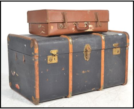 A vintage 20th Century canvas and cane bound steamer trunk, hinged top with latches to the front together with a similar aged