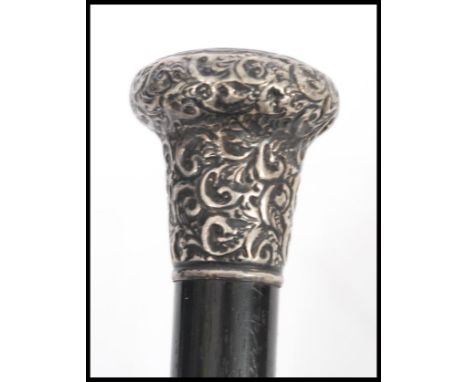 A 19th century Victorian walking stick cane having a tapering ebony shaft with scrolled and foliate engraved silver hallmarke