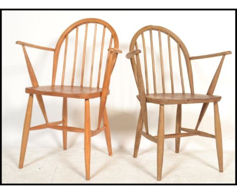 A near pair of Ercol light elm and beech&nbsp; hoop back carver dining chairs, the chairs with solid seat pads raised on tape