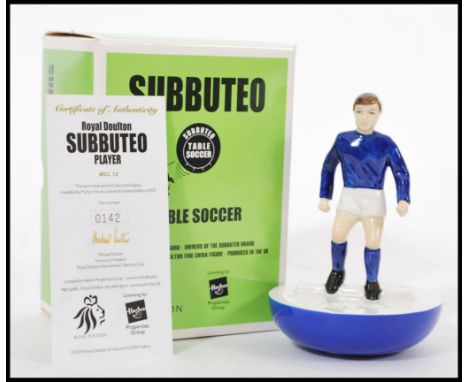 A Royal Doulton ceramic advertising figurine of a Subbuteo player in blue and white kit. MCL12 142/500. Complete in original 