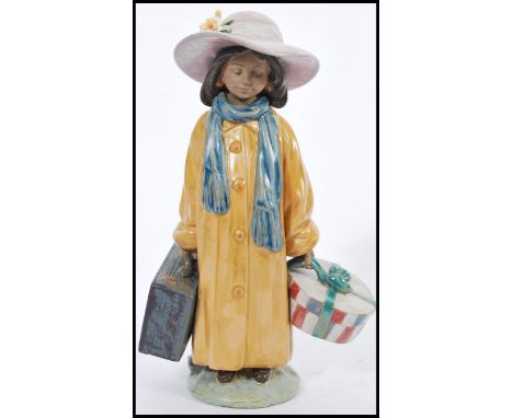 A LLadro ceramic figurine of a girl with luggage model 2388 being stamped to base. 28cm high.&nbsp;