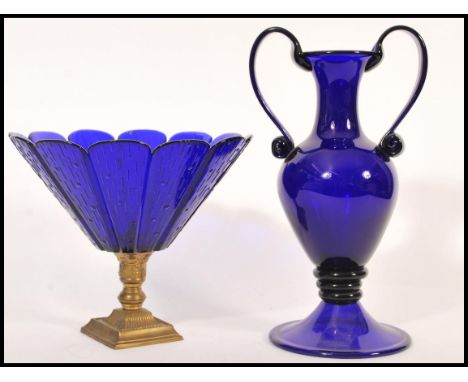 Two blue glass wares to include a large Bristol blue acid signed twin handled vase raised on circular base with scrolled hand