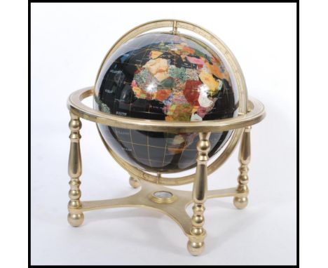 A vintage 20th century large terrestrial globe having semi precious stone inlay. Black stone ground with brass mounts and com