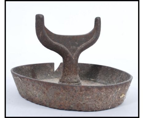 A 19th century cast iron boot scraper of architectural form raised on oval high sided base with shaped scrape. 17cm high 28cm