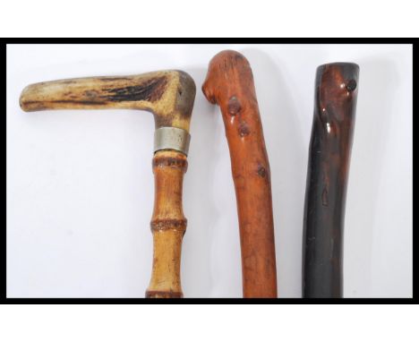 A collection of three 20th Century walking sticks / canes to include a bamboo stick having a silver white metal collar and sh