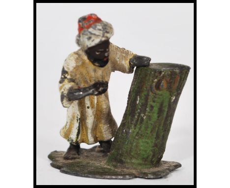 An early 20th century cold painted bronze miniature of an Arab man resting by a tree trunk. Measures 4cm-high 4cm-wide.