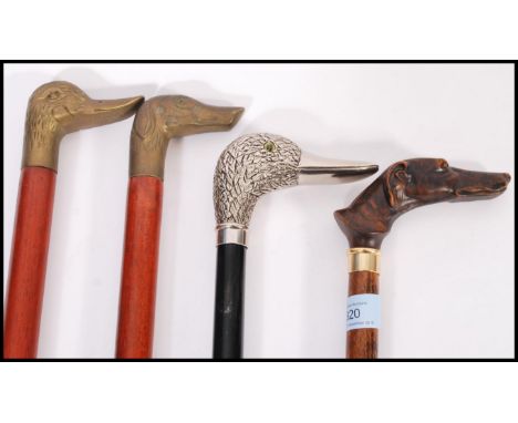 A group of vintage walking stick canes all having figural handles to include a silver plated duck handle example, carved wood