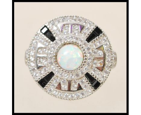 A stamped 925 silver Art Deco style ring with a round head set with a central opal and surrounded by sapphires and cz's in a 