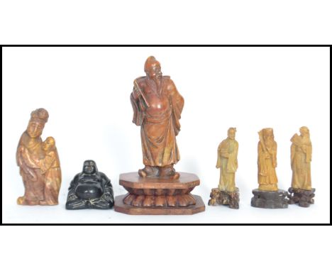 A group of Chinese carved soapstone figures dating from the 19th century to include elder wooden pedestal base holding panels