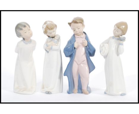 A group of four tall Lladro type Nao figurines to include Child with pillow and clock, Girl with doll, kissing boy and anothe