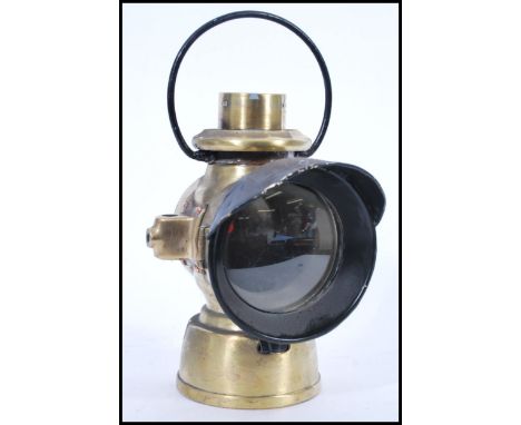 An early 20th Century brass motor car side lamp believed to be Lucas (unmarked), having a painted loop handle to the top, and