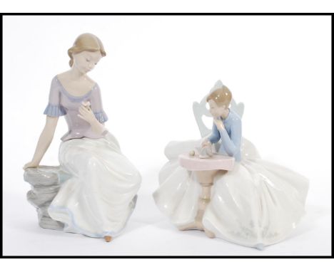 A pair of Lladro type Nao figurines of seated figures models 1355 and 1392. Printed marks to base. Tallest 29cm high.&nbsp;