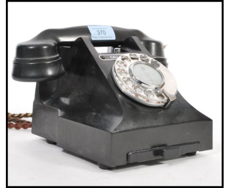 A vintage 1950's rotary bakelite telephone on a square base, having a pull out phone number tray, adapted for modern use, wit