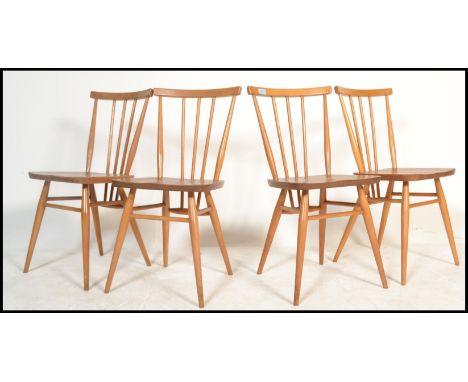 A set of four vintage retro 20th century Ercol beech and elm Windsor model 391 dining chairs having stick backs with shaped b