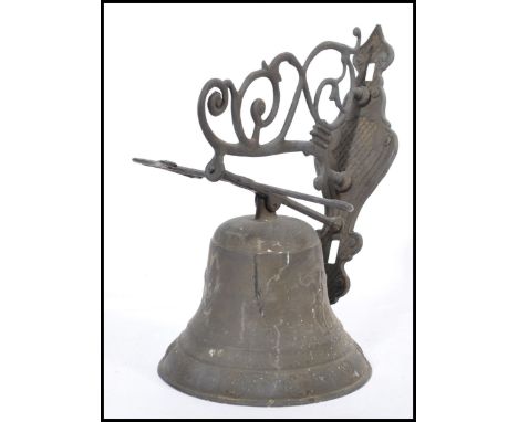 A vintage early 20th century Art Nouveau cast metal bell having cherub and shell mask decoration.