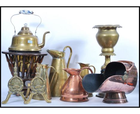 A large collection of vintage copper and brass wares to include a graduating set of brass jugs, blue and white ceramic handle