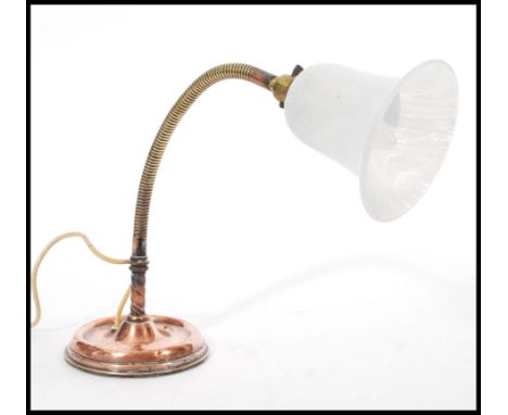 A vintage retro 20th century industrial copper gooseneck desk lamp raised on a circular base with adjustable neck and glass s