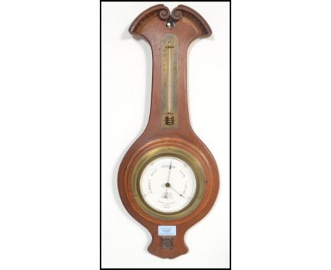 A 20th Century wooden case wall barometer / thermometer by Negretti &amp; Zambra having a scrolled decoration top, and floral