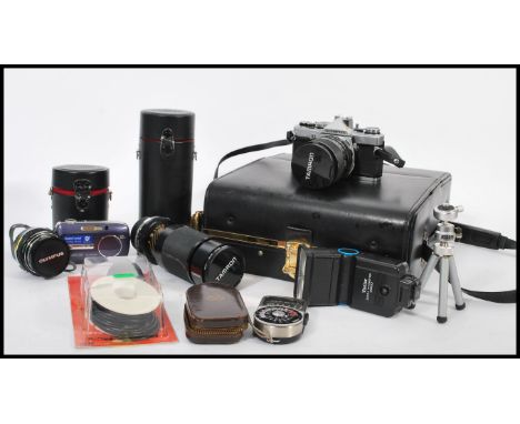 A collection of vintage cameras to include SLR camera body, SLR lenses to include zoom, protective cases and camera equipment