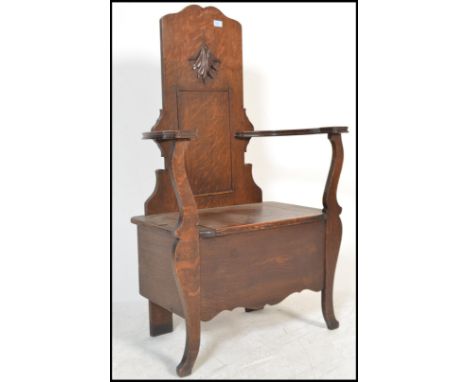 A 1920's oak Jacobean revival JAS Shoolbred of London oak hall settle chair / bench. The seat with hinged top having chest wi