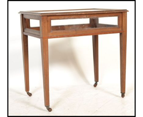 An Edwardian mahogany inlaid bijouterie table / display cabinet. Raised on square tapered legs with brown ceramic castors hav