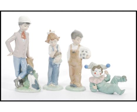 A group of four Lladro type Nao figurines to include reclined clown child, boy with ball, boy at tree stump with a dog and a 