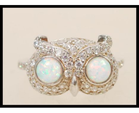 A stamped 925 silver ring in the form of an owl set with two round opals for eyes with cz stones surrounding it. Weight appro