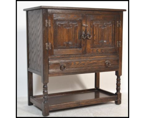 An Old Charm / Jaycee style oak hall cupboard having carved linen fold decoration being raised on bobbin tuned legs.&nbsp;Mea