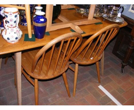 An Ercol light finish dining table - 150cm x 75cm, together with the set of four stick-back dining chairs