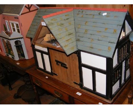 A model barn dolls house with pitched roof, complete with extensive furnishings - length 80cm