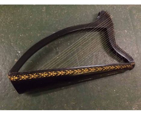 An unusual small 32 string harp, the body decorated in gilt on a black background, requiring some restoration, unsigned 