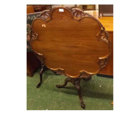 Reproduction mahogany supper table in the Georgian style, the top with lobed and shell carved detail, raised on a turned colu