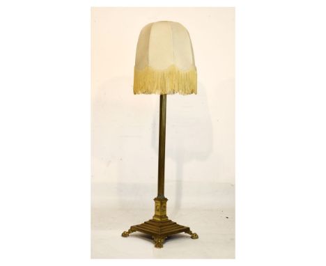 Early 20th Century brass Corinthian column standard lamp, the reeded column on stepped square base and four paw feet, sold wi