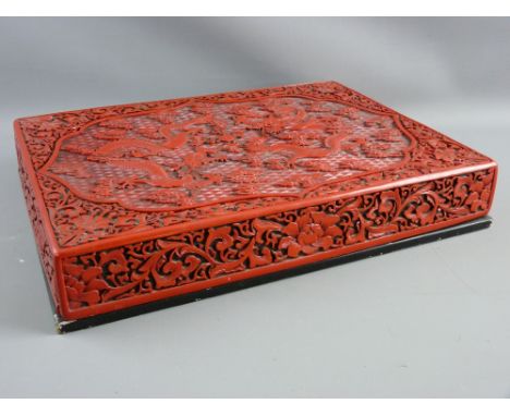 A CHINESE RED LACQUERWORK CARVED CINNABAR STYLE BOX, the lift-off lid with floral decorated sides repeated to the top corners