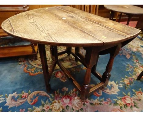 AN ANTIQUE OAK GATE LEG DINING TABLE, the peg joined sub frame on turned and block supports and simple frame leaf supports, 7