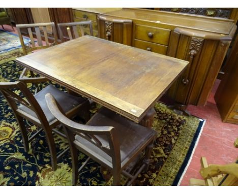 A VINTAGE OAK DINING SUITE of sideboard, draw leaf table and four chairs, all having carved detail on bulbous supports