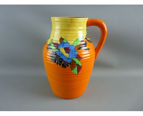 A CIRCA 1920 SINGLE HANDLE LOTUS 'INDIAN SUMMER' JUG, 29 cms high with ribbed body having a vibrant orange and yellow ground,