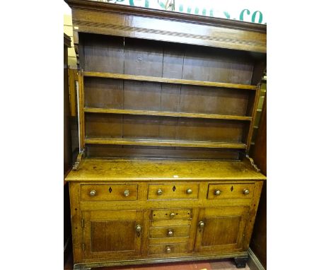 AN EARLY 19th CENTURY NORTH WALES OAK DRESSER of excellent colour and patina, the three shelf box canopy rack with shaped sid