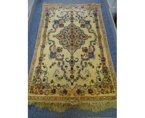 AN ISFAHAN WOOL RUG, fawn ground with centre shaped floral panel and surrounding flowers, 1.65 x 1.05 metres