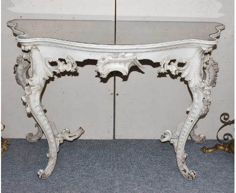 A mirrored console table in the Victorian style, with serpentine mirror top above a foliate carved frieze, on flowerhead carv