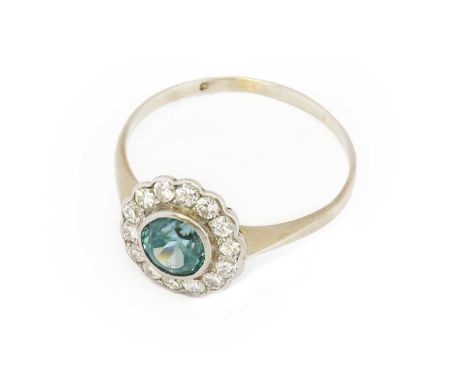 A blue zircon and diamond cluster ring, the round cut blue zircon within a border of round brilliant cut diamonds, in white r