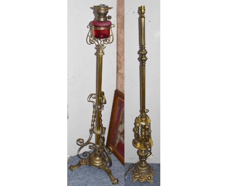 A Victorian brass adjustable oil lamp, the Cranberry Glass reservoir above a brass column on scroll supports and triform base